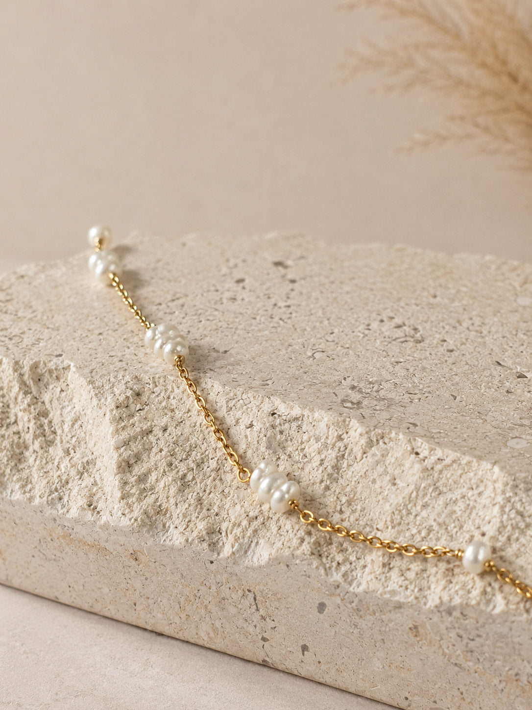 Gouden ketting met kleine zoetwaterparels, hangend gefotografeerd