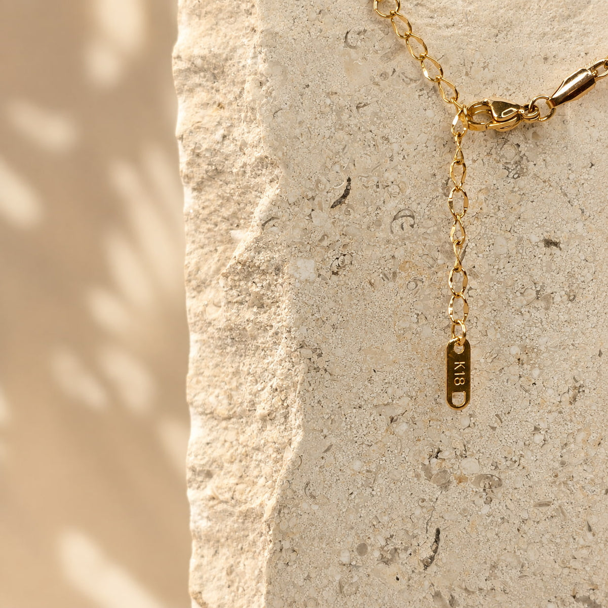 Sluiting en verstelbaar verlengkettinkje met K18 label van de gouden Daisy Necklace van hi SISU